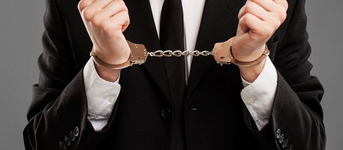 Businessman in suit with closed manacles on his hands