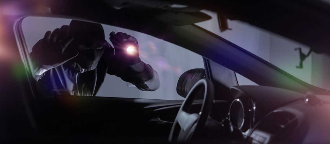 Car Robber with Flashlight Looking Inside the Car. Car Security Theme.